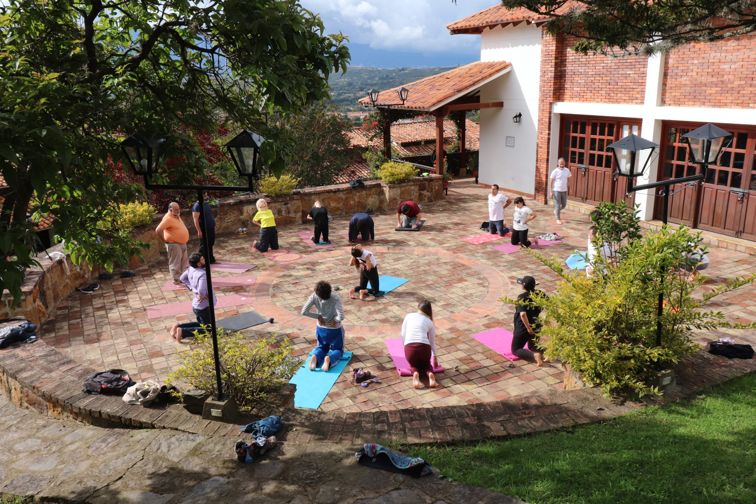 People follow a yoga class outside sitting in a circle.