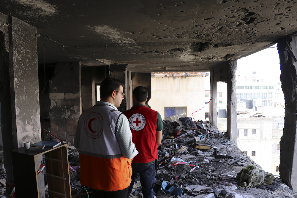 Gaza. ICRC and Palestine Red Crescent Society staff walk through a damaged home, assessing the impact and risks posed to those who live there.